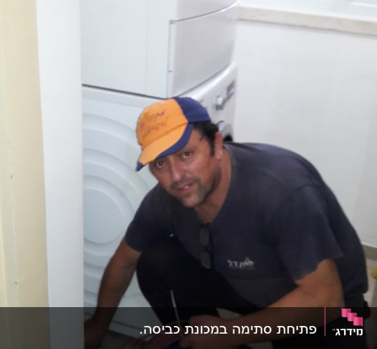 אדם מחזיק כבל ליד מכונת כביסה